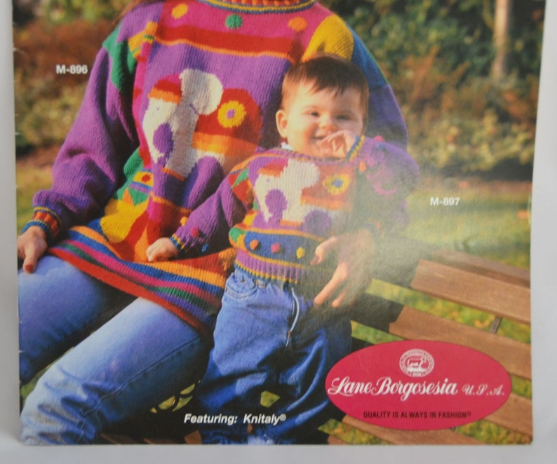 K&ouml;nnte beinhalten: Eine Frau und ein Kind tragen passende bunte Strickpullover mit einem fantasievollen Tiermotiv. Die Pullover sind in verschiedenen Farben gehalten, darunter Lila, Rosa, Gelb, Gr&uuml;n und Blau. Die Pullover sind aus einem strukturierten Strickstoff gefertigt und haben ein verspieltes, fantasievolles Design. Die Pullover sind Teil einer Strickmusterkollektion von Lane Borgosesia U.P.A. mit Knitaly.