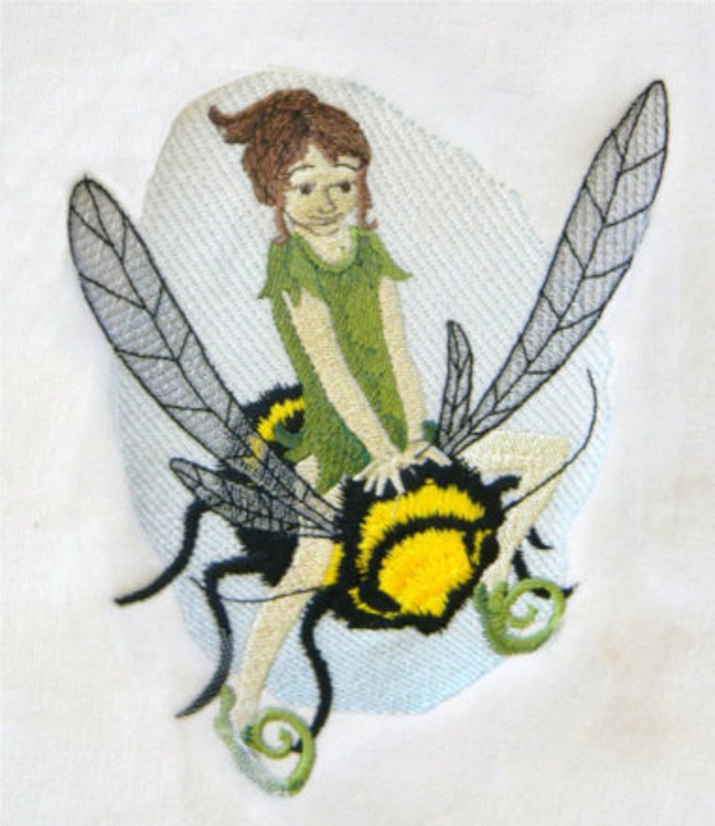 May include: Embroidered design of a fairy riding a bee. The fairy is wearing a green dress and has brown hair. The bee is black and yellow with wings.