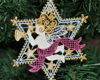 Pode incluir: Um anjo branco com asas douradas e prateadas e uma fita rosa toca trombeta dentro de um ornamento em forma de estrela azul e dourada.