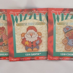 Op de afbeelding: Drie Sugarplum Christmas Whizzers geteld kruissteekpakketten met peperkoekpoppetjes. De pakketten zijn gelabeld met "Gingerbread", "Santa" en "Cookie Man".
