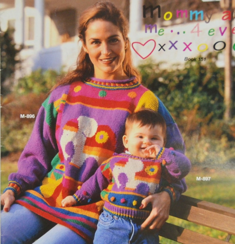 K&ouml;nnte beinhalten: Eine Frau und ein Kind tragen passende bunte Pullover mit einem Comic-Tier-Design. Die Pullover haben Streifen in Rot, Gelb, Gr&uuml;n, Blau und Lila. Der Text "Mommy and Me... 4 ever XXX O" steht &uuml;ber dem Kopf der Frau. Der Text "Book 151" steht unter dem Kopf der Frau. Der Text "M-896" steht in der oberen linken Ecke des Bildes. Der Text "M-897" steht in der unteren rechten Ecke des Bildes.