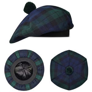 May include: A tam o' shanter hat featuring a blue and green tartan plaid pattern. The hat includes a dark green pom-pom on the top center, a black ribbed headband, and a smooth black interior lining visible from the underside view of the cap.