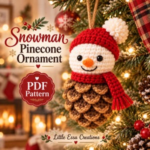 May include: A crocheted snowman pinecone ornament featuring a white head, a red hat with a white pom-pom, and a red scarf. The text reads Snowman Pinecone Ornament, PDF Pattern, and Little Essa Creations. The ornament hangs from a jute string.