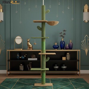Peut inclure: Un arbre &agrave; chat vert et beige avec un design de cactus. L'arbre &agrave; chat comporte plusieurs plateformes, un panier tress&eacute; et un jouet suspendu. La base est carr&eacute;e et l'arbre est plac&eacute; contre un mur turquoise avec des &eacute;l&eacute;ments d&eacute;coratifs.