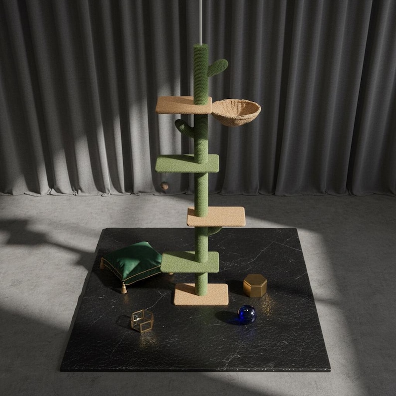 Peut inclure: Un arbre &agrave; chat vert et beige avec une conception en forme de cactus, des plateformes et un panier en osier. L'arbre &agrave; chat est sur une surface noire avec un coussin vert, un objet g&eacute;om&eacute;trique dor&eacute; et une sph&egrave;re de verre bleue.