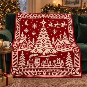 Könnte beinhalten: Eine rot-weiße Strickdecke mit einer festlichen Weihnachtsszene, die einen zentralen Weihnachtsbaum, einen dampfenden Zug mit Geschenken, ein Dorf mit Häusern, eine Mondsichel, Schneeflocken und einen Schlitten mit Rentieren in einer Bordüre zeigt.