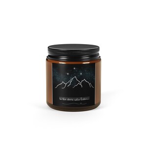 Peut inclure: Un pot en verre brun avec un couvercle noir. L'étiquette présente une silhouette de chaîne de montagnes sous un ciel étoilé. Le texte "to the stars who listen" est écrit en dessous.
