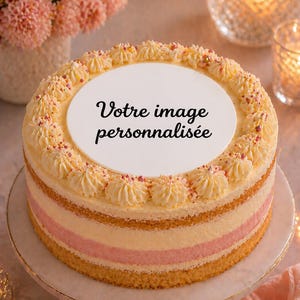 Könnte beinhalten: Ein mehrschichtiger Kuchen mit einer weißen, kreisförmigen Oberseite, verziert mit Sahne-Frosting und rosa Streuseln. Der Kuchen hat einen rosa Streifen in der Mitte und steht auf einer weißen und goldenen Kuchenplatte. Der Text "Votre image personnalisée" steht oben.