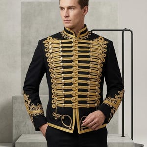 May include: A black military-style jacket featuring a high collar and elaborate gold braided cord detailing across the front. The garment includes rows of round gold buttons and intricate gold embroidery patterns on the cuffs and hem.