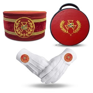 Op de afbeelding: Een assortiment ceremoniële items, waaronder een rode fluwelen hoed met gouden details, een ronde rode koffer en witte handschoenen. Elk item is voorzien van een gouden embleem met een geometrisch ontwerp en lauwerkrans.