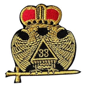 May include: An embroidered patch featuring a gold double-headed eagle with wings spread, topped by a red and gold crown. A black triangle with the number 33 in gold is centered on the eagle's chest, and a horizontal gold sword rests below.