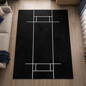 Könnte beinhalten: Ein rechteckiger Teppich mit einfarbig schwarzem Hintergrund und einem weißen, linearen geometrischen Muster. Das Design besteht aus zwei langen vertikalen Linien, die von kürzeren horizontalen Linien gekreuzt werden.