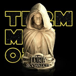 May include: A beige bust of Luke Skywalker wearing a hooded cloak, positioned on a circular base featuring the text STAR WARS LUKE SKYWALKER. The figure has a textured fabric appearance and is set against a black background with yellow text.