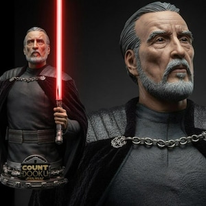 May include: A detailed bust of Count Dooku from Star Wars, featuring a gray-haired figure with a beard, wearing a dark gray tunic and a black cape fastened with a silver chain. The figure holds a lightsaber with a glowing red blade.