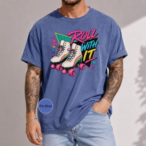 A man wearing a blue t-shirt with a graphic design of roller skates and the text "Roll with it" printed on it.