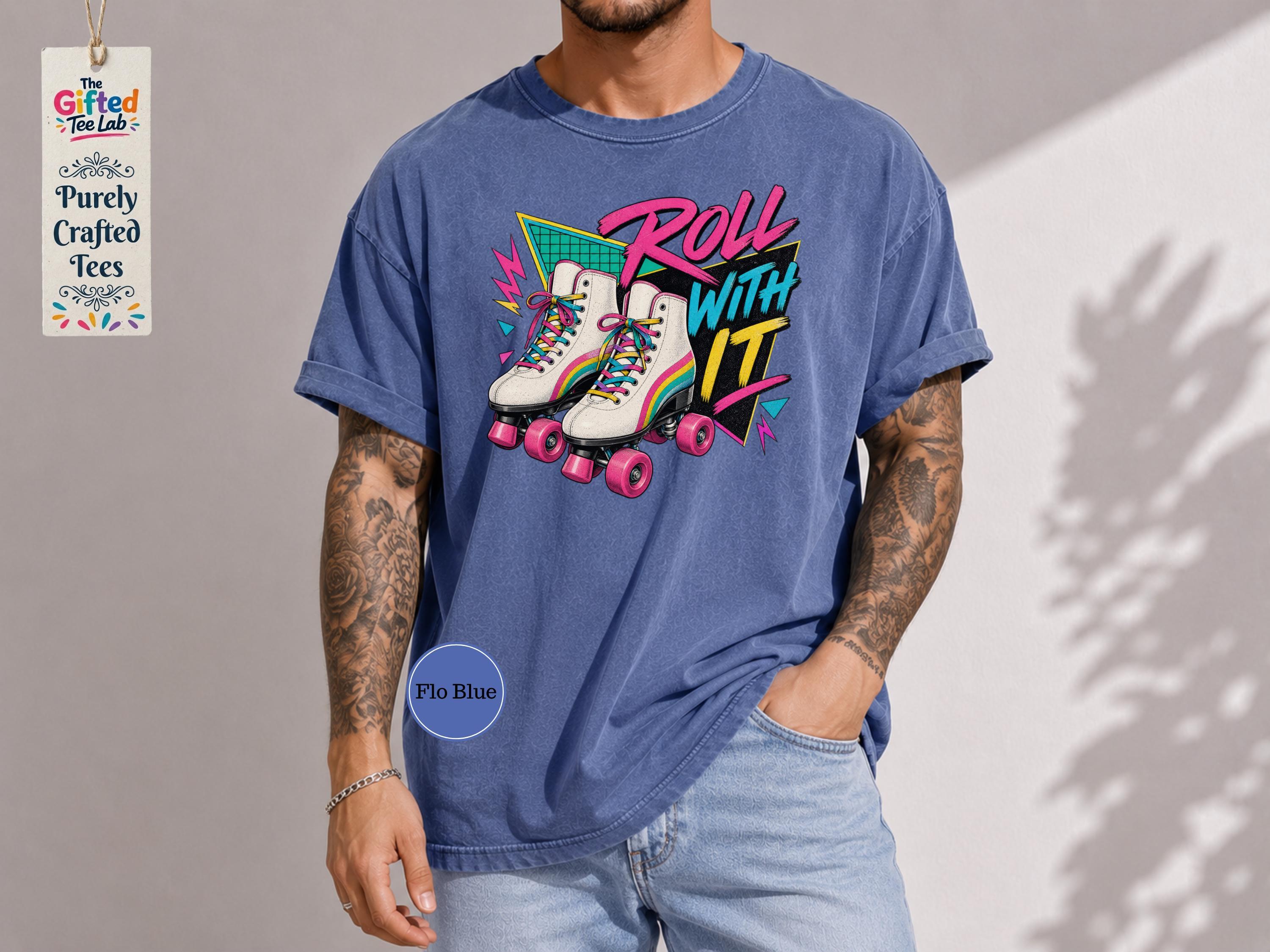 A man wearing a blue t-shirt with a graphic design of roller skates and the text "Roll with it" printed on it.