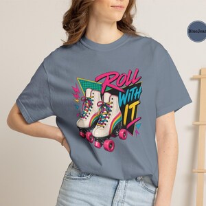 a t-shirt with a graphic design of roller skates, along with various other items such as a hat, a notebook, and a small bowl.
