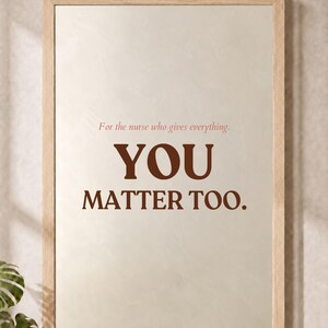 May include: A rectangular wall art print in a light wood frame featuring a beige background with the text "For the nurse who gives everything. YOU MATTER TOO." in dark brown and muted red lettering. The bottom text reads "PRINT ONLY. FRAME FOR DISPLAY."