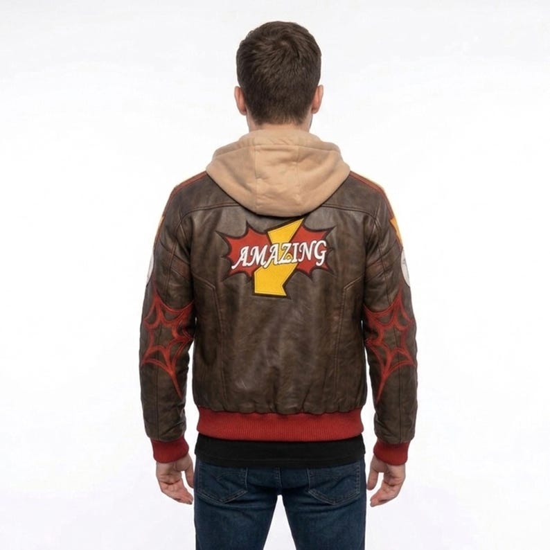 Rear view of a man on a city rooftop wearing Marvel Rivals Inspired Spider-Man Bomber Leather Jacket with Hoodie with red web designs on the sleeves and a large red and yellow patch reading "AMAZING" on the back.