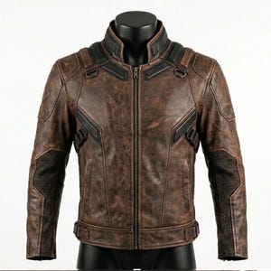May include: A distressed brown jacket with a weathered finish, featuring a central zipper, a high collar, and black panel accents on the shoulders and chest. The garment includes side straps at the waist and textured mesh sections on the sleeves.