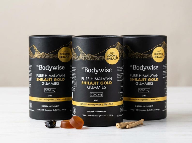 Pode incluir: Tr&ecirc;s recipientes cil&iacute;ndricos pretos de "Bodywise" Pure Himalayan Shilajit Gold Gummies, cada um com um design de montanha dourada e o texto "with 3000mg Shilajit". A imagem tamb&eacute;m mostra gomas e outros ingredientes.