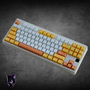 May include: A mechanical keyboard featuring a white frame and a color scheme of white, yellow, and orange keycaps. The layout includes a standard QWERTY arrangement with specific orange accent keys, including the spacebar and arrow keys.