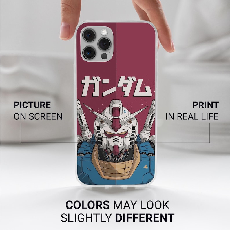May include: A smartphone case featuring a graphic illustration of a Gundam robot head in white, blue, and tan colors against a dark red background. The Japanese text "ガンダム" is printed above the robot. The case has a camera cutout at the top.
