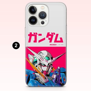 May include: A clear smartphone case featuring a graphic design with the Japanese text ガンダム, the word WAMZA, and an illustration of a white and blue robot head against a vibrant pink background, with a small figure standing in the foreground.