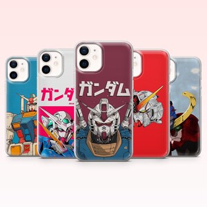 May include: Five clear smartphone cases featuring various Gundam robot illustrations. The center case displays a detailed robot head with the Japanese text ガンダム printed above it. Other cases show full-body or close-up robot designs in blue, red, and white color schemes.