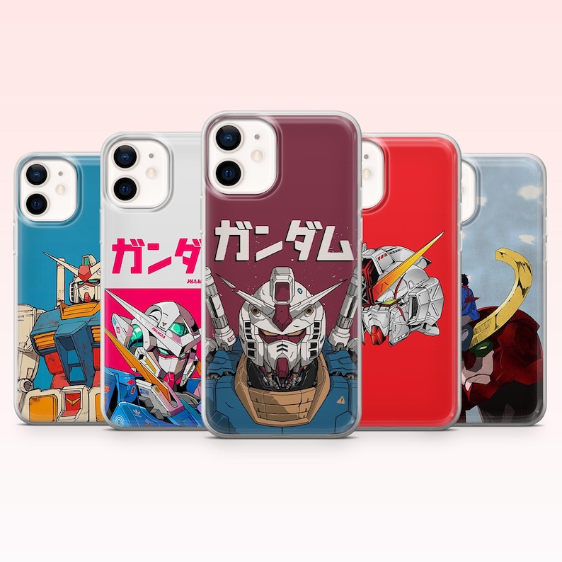 May include: Five clear smartphone cases featuring various Gundam robot illustrations. The center case displays a detailed robot head with the Japanese text ガンダム printed above it. Other cases show full-body or close-up robot designs in blue, red, and white color schemes.