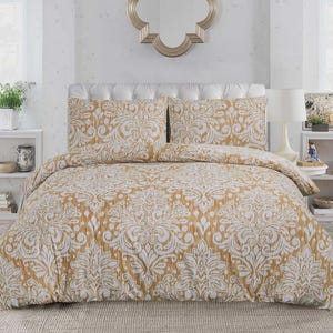 May include: A bedding set featuring a mustard yellow and white damask pattern. The set includes a duvet cover and two matching pillow shams, all displaying a repeating ornate floral motif across the fabric surface, creating a cohesive look.