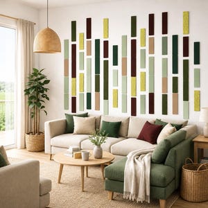 Op de afbeelding: Een moderne woonkamer met een beige hoekbank, een groene chaise longue en een ronde houten salontafel. De muur is voorzien van verticale rechthoekige panelen in groen, geel en bruin. Boven de tafel hangt een hanglamp van gevlochten materiaal.