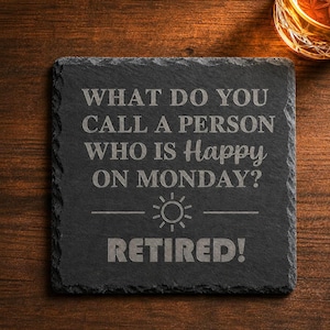 May include: A square black slate coaster with rough, natural edges. The surface is engraved with the text: WHAT DO YOU CALL A PERSON WHO IS Happy ON MONDAY? followed by a sun icon and the word RETIRED! in large, bold, capital letters.