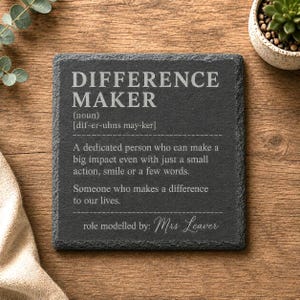 May include: A square dark grey slate coaster with rough, textured edges. The surface features white engraved text that reads: DIFFERENCE MAKER (noun) [dif-er-uhns may-ker] A dedicated person who can make a big impact even with just a small action, smile or a few words. Someone who makes a difference to our lives. role modelled by: Mrs Leaver.
