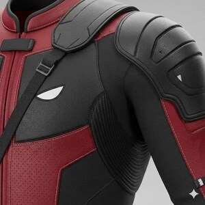 May include: A black and red motorcycle jacket featuring textured leather panels, reinforced shoulder padding, and a black shoulder strap. The design includes white eye-shaped accents on the chest and a perforated red leather section on the front.