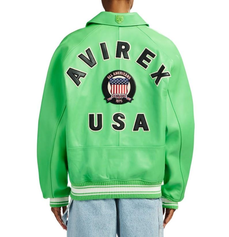 May include: A bright lime green leather varsity jacket featuring the text AVIREX in black letters arched above a circular patch with a flag design and the text ALL AMERICANS ESTABLISHED 1975, with the word USA in black letters below the patch.
