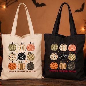 May include: Two canvas tote bags, one cream and one black, each featuring a grid of nine illustrated pumpkins with various patterns and the text "SARAH'S PUMPKIN PATCH" printed in a simple font at the bottom of the bag design.
