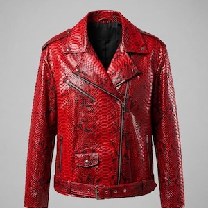 May include: A bright red motorcycle jacket featuring a textured snakeskin pattern with black accents. The jacket includes a diagonal front zipper, a notched collar with metal snaps, zippered pockets, a small flap pocket, and a buckled waist belt.