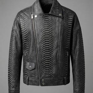 May include: A black motorcycle-style jacket featuring a textured snakeskin pattern throughout. The jacket includes an asymmetrical front zipper closure, a notched lapel with a silver-tone snap button, two zippered side pockets, and a small flap pocket.
