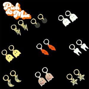 May include: A collection of hoop earrings featuring various charms including lightning bolts, black cat silhouettes, white ghosts, yellow ghosts, orange lips, white teeth, crescent moons, and stars, with the text Pick & Mix in the top left corner.