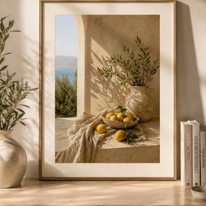 Puede incluir: Una impresión enmarcada que presenta una naturaleza muerta con limones. Un cuenco de limones amarillos descansa sobre una repisa de piedra, cubierto con un paño beige. Un jarrón con ramas verdes está en el fondo. La escena está iluminada por la luz del sol.