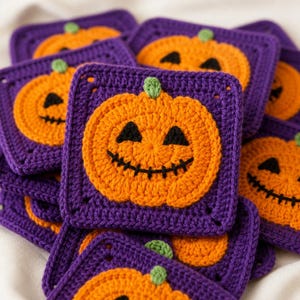 May include: A collection of square crochet motifs featuring a central orange pumpkin with a green stem and a black stitched jack-o'-lantern face. Each pumpkin is centered on a solid purple square background with a textured, hand-stitched appearance.