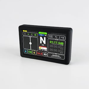 Puede incluir: Una pantalla digital negra en un marco negro, que muestra datos de carreras. La pantalla muestra los tiempos de vuelta, la velocidad y otras métricas. La pantalla muestra "OFFLINE TESTING" y "01:17.546".