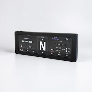 May include: A rectangular black digital racing dashboard display featuring a high-contrast screen with white text and graphics. The interface shows various telemetry data including lap times, gear position N, and fuel levels with N/A indicators.