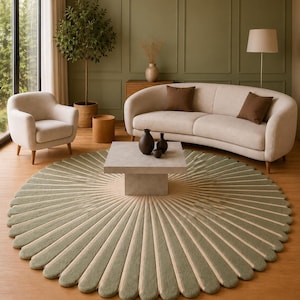 May include: A stylish living room with a large, circular rug in green and beige, featuring a fan-shaped pattern. The room includes a beige sofa, armchairs, a coffee table, and decorative vases. The walls are painted in a muted green.