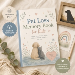 May include: A pet loss memory book for kids with the text "Pet Loss Memory Book for Kids". The cover features an illustration of a dog and cat. Includes a framed photo of a dog, a rainbow illustration, and a pencil.