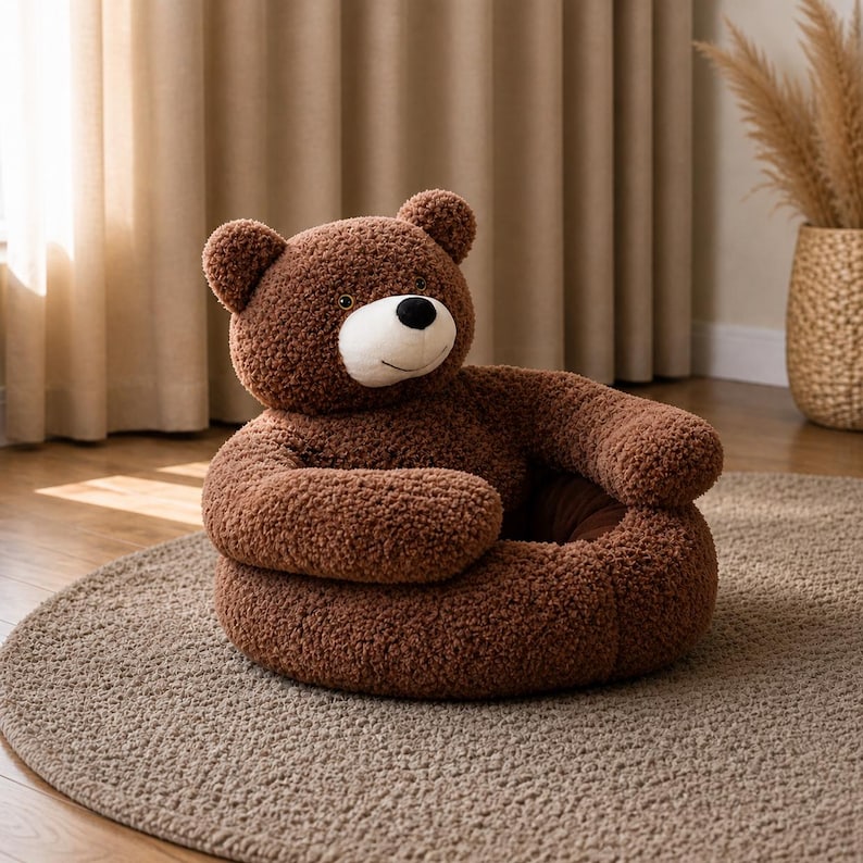 May include: A brown teddy bear chair with a round base and arms. The chair has a plush, textured appearance and a white and black face. The chair is sitting on a round, neutral-colored rug.