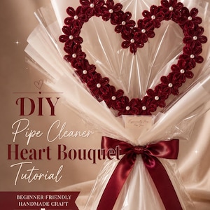 May include: A heart-shaped bouquet made of dark red pipe cleaner flowers with white pearl centers, wrapped in translucent white paper and tied with a dark red satin ribbon. The text reads: DIY Pipe Cleaner Heart Bouquet Tutorial.