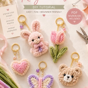 May include: A collection of five handmade pipe cleaner keychains in the shape of a bunny, tulip, heart, butterfly, and bear. The keychains are in shades of pink, purple, and beige, with gold-colored key rings. The image includes text that says "5 Cute Pipe Cleaner Keychains".