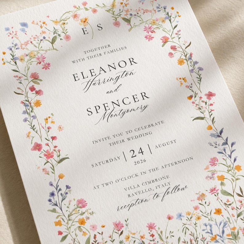 Close-up of floral wedding invitation printed on premium textured cotton cardstock highlighting delicate wildflower border and elegant typography.